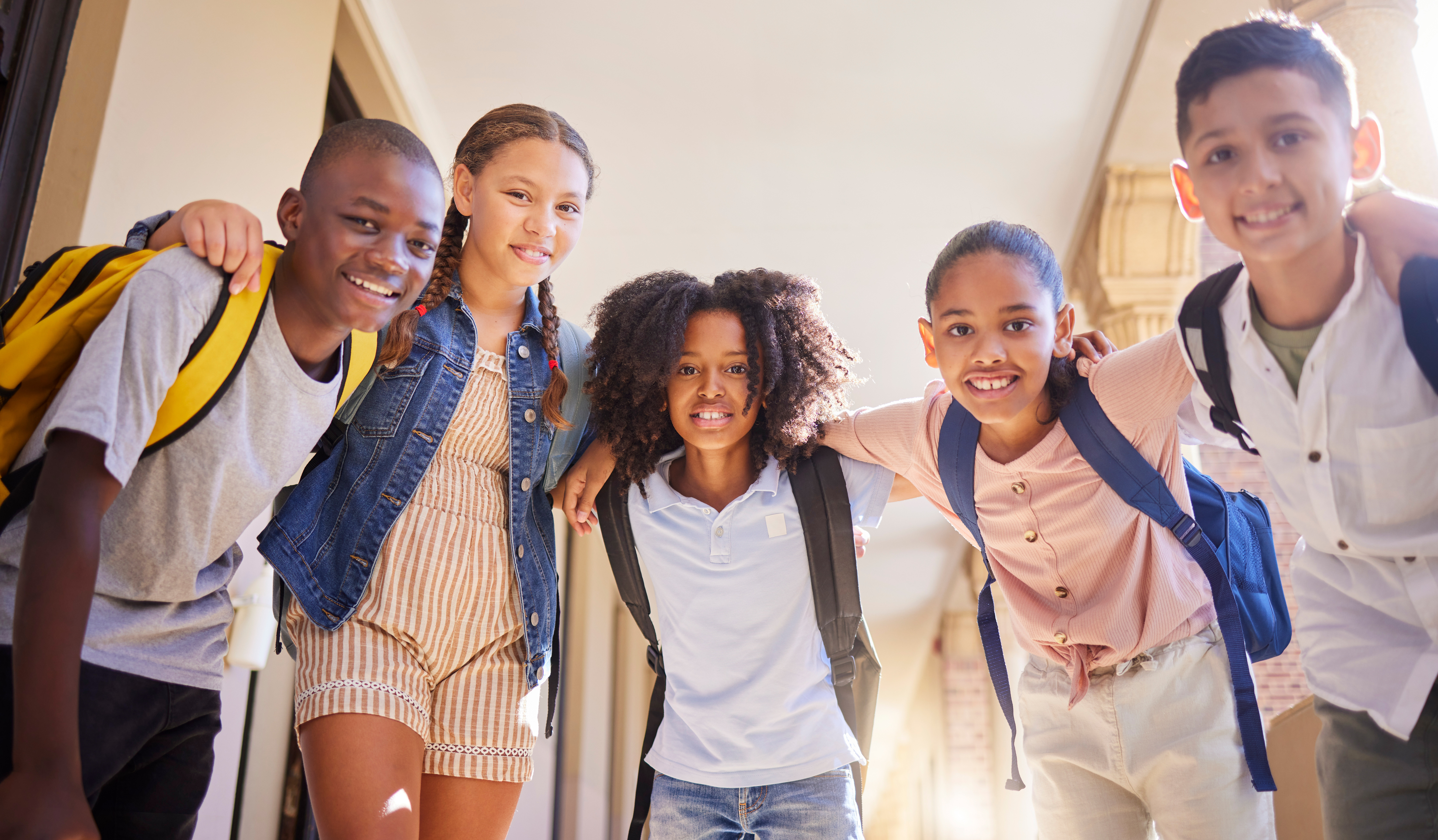 A group of school children linking arms and smiling