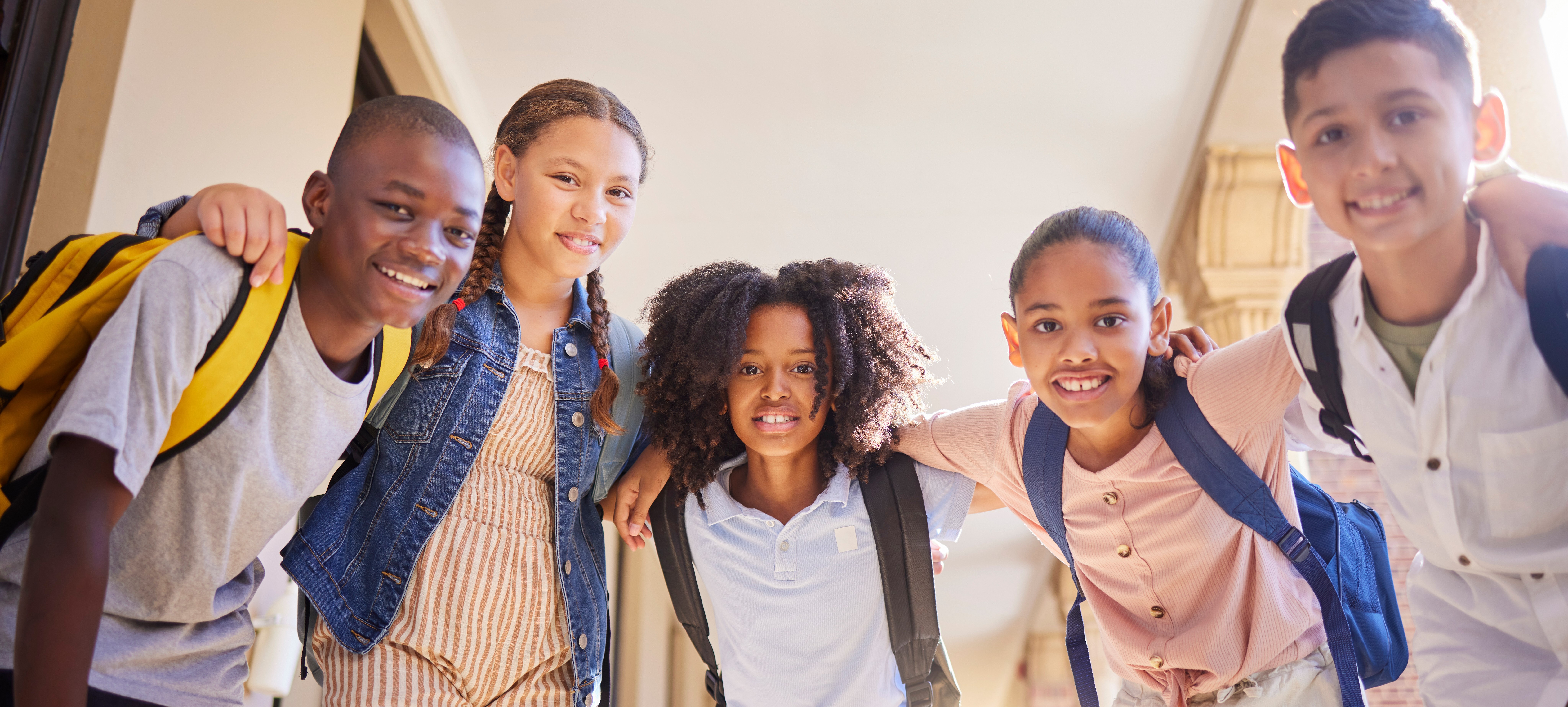 A group of school children linking arms and smiling