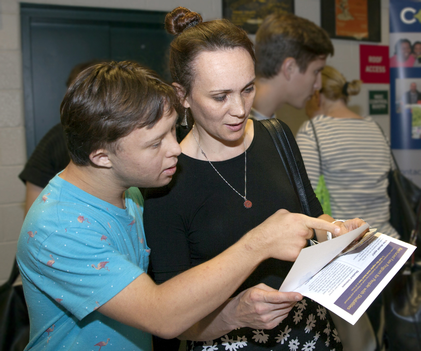 A mom and son look at information at a Transitioning Youth fair.